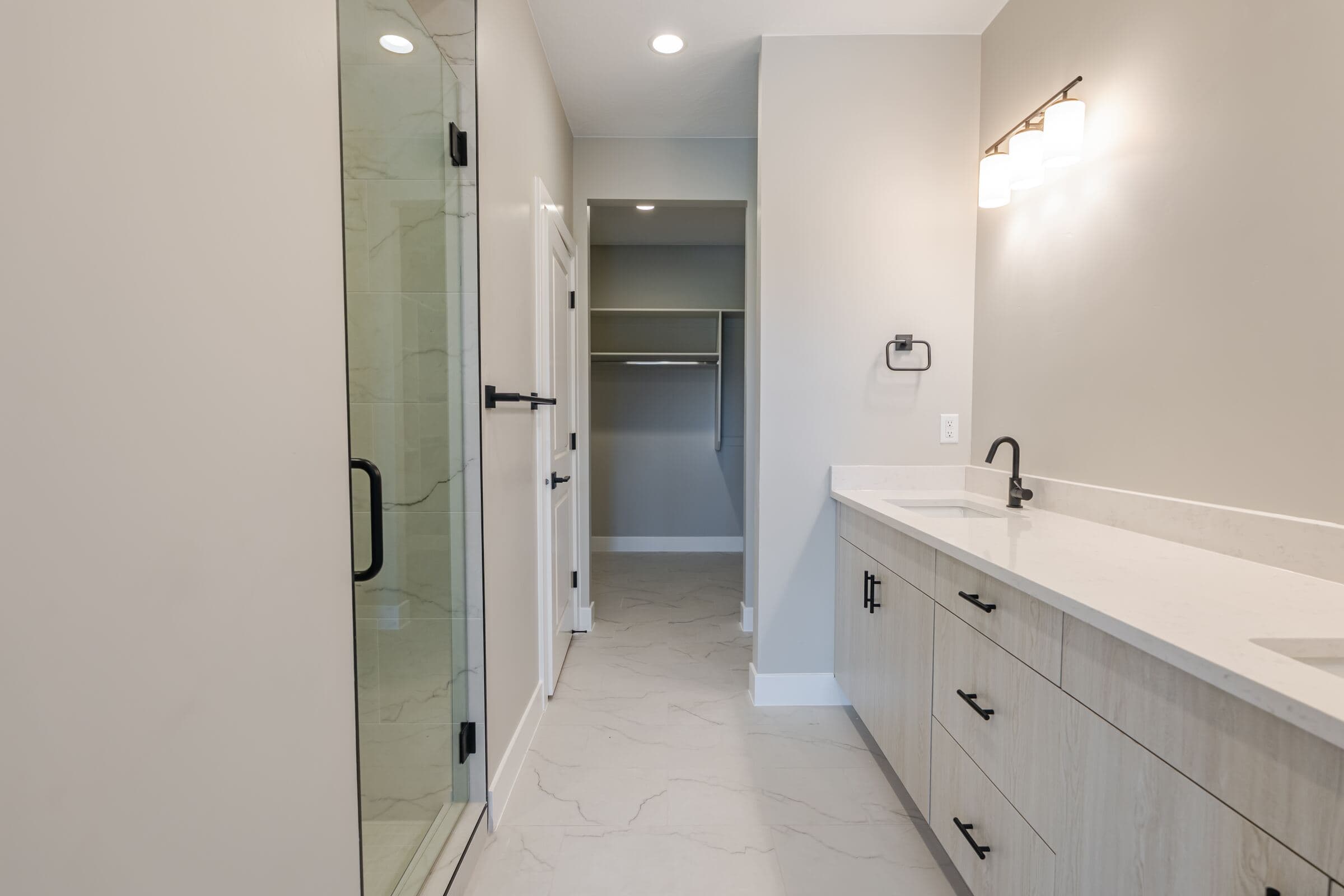 Primary bathroom with glass-enclosed walk-in shower and dual-sink vanity