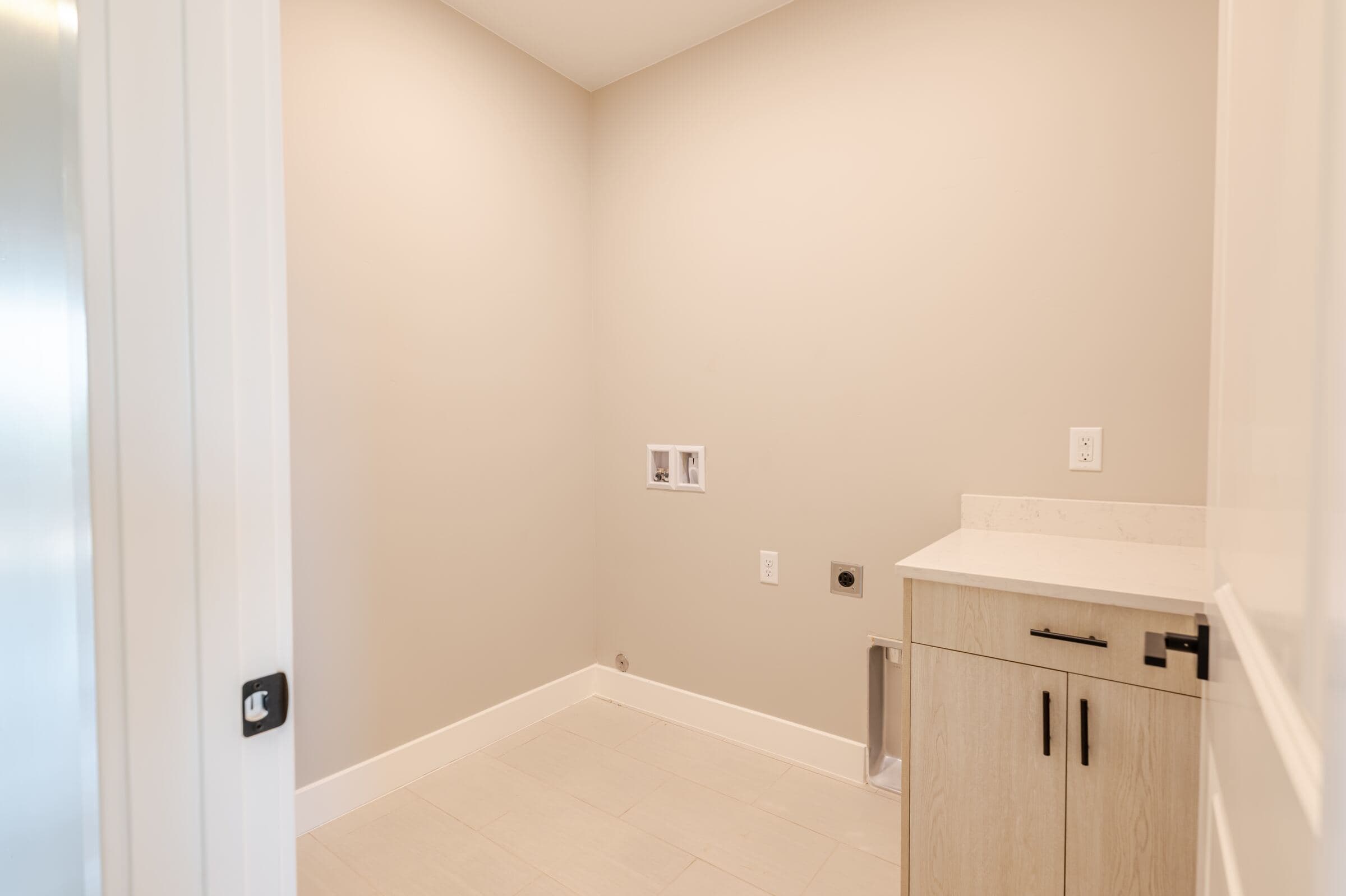 Dedicated upstairs laundry room with cabinetry